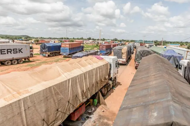 Camions bloqués à la frontière Bénin-Niger en 2023, illustrant les conséquences de la crise