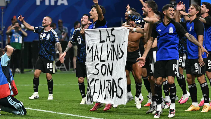Joueurs argentins tenant une banderole revendiquant les Malouines